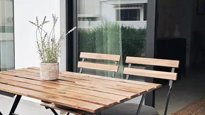 a wooden table with two chairs and a vase on it at City and Sea 12 in Larnaka