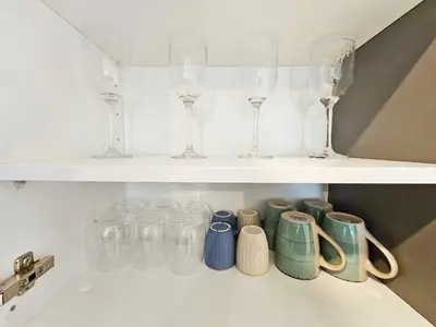 a shelf filled with glasses and wine glasses at Alexander Residence Trikallon Str in Nicosia