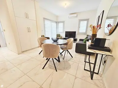 a living room with a table and chairs and a couch at Alexander Residence Trikallon Str in Nicosia