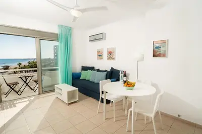 a living room with a table and a couch at Stunning Mackenzie Sea Views Beach Flat,1 Bedroom in Larnaka
