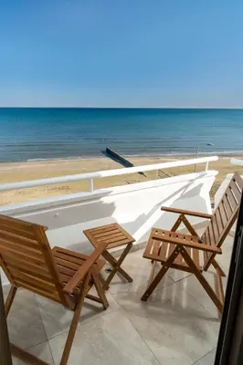 two chairs sitting on top of a balcony overlooking the ocean at Stunning Mackenzie Sea Views Beach Flat,1 Bedroom in Larnaka