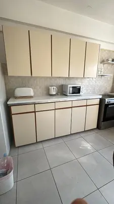 a kitchen with white cabinets and a microwave at City Center Getaway in Nicosia