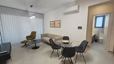 a living room with a couch and a table and chairs at STAY Engomi Gem 2 in Engomi