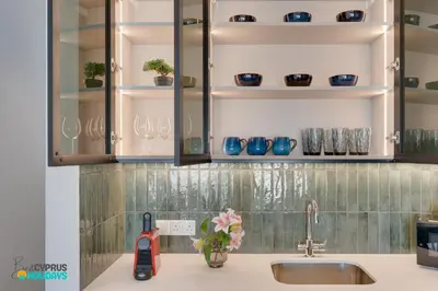 a kitchen counter with a sink and shelves with dishes at Lordos Deluxe 2bd Duplex with pool and Seaview in Larnaka