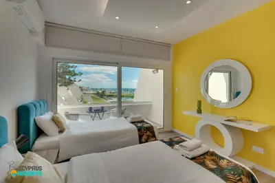 a hotel room with two beds and a window at Lordos Deluxe 2bd Duplex with pool and Seaview in Larnaka
