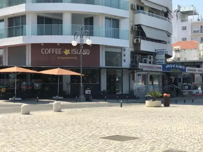 a city street with a coffee stand in front of buildings at Panoramic Sea View Apartments in Larnaka