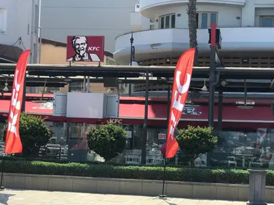 two red and white flags in front of a building at Panoramic Sea View Apartments in Larnaka
