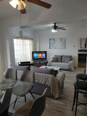 a living room with couches and a flat screen tv at Panoramic Sea View Apartments in Larnaka