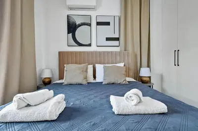 a bedroom with a blue bed with towels on it at STYLE Limassol by Ezoria Villas in Limassol