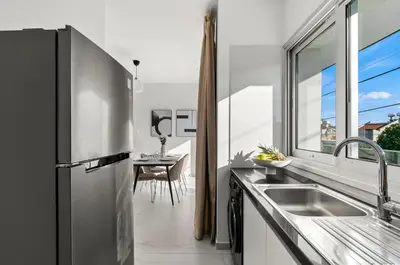a kitchen with a stainless steel refrigerator and a window at STYLE Limassol by Ezoria Villas in Limassol