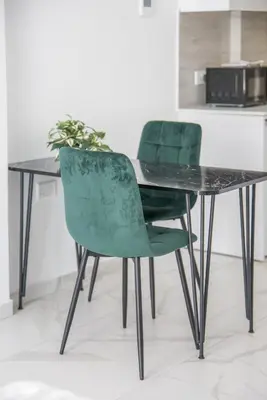 a black table with two green chairs sitting next to it at Mackenzie Signature Studio Suite in Larnaca in Larnaka