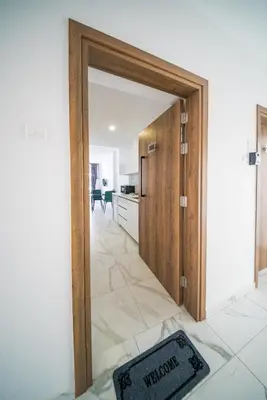 a door to a kitchen with a sign on the floor at Mackenzie Signature Studio Suite in Larnaca in Larnaka
