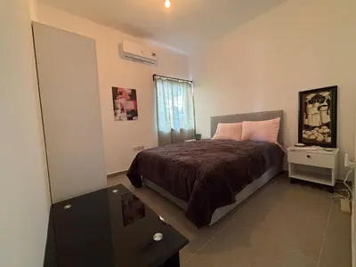 a bedroom with a bed with pink pillows and a window at Flat Koskluciftlik in Nicosia