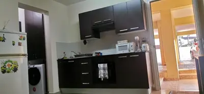 a kitchen with black cabinets and a white microwave at 2br-7 Guests-Free Parking-Pool-AirCon in Paralimni