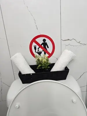 a bathroom with a toilet with a sign on it at Marble Coast Studio Apartment in Larnaka