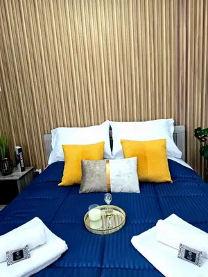 a blue bed with yellow pillows and a tray on it at Marble Coast Studio Apartment in Larnaka