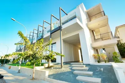 a white house with stairs and a tree at SunnyVillas Suite Mythical GYM Swimming Pool S19 in Paralimni