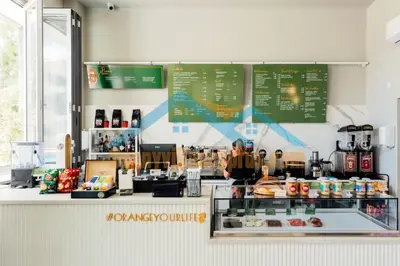 a woman standing behind the counter of a coffee shop at SunnyVillas Suite Mythical GYM Swimming Pool S19 in Paralimni