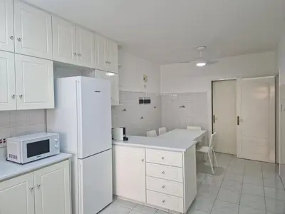 a kitchen with white cabinets and a white refrigerator at Urban Nest Central Nicosia - Spacious 2BR Apartment in Nicosia