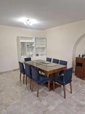 a dining room with a wooden table and blue chairs at Urban Nest Central Nicosia - Spacious 2BR Apartment in Nicosia