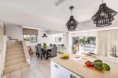 a kitchen and dining room with pendant lights at Pantaros Luxury Villas with pool in Paralimni