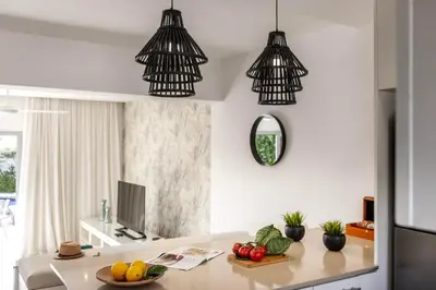 a kitchen with two pendant lights and a table with fruits at Pantaros Luxury Villas with pool in Paralimni