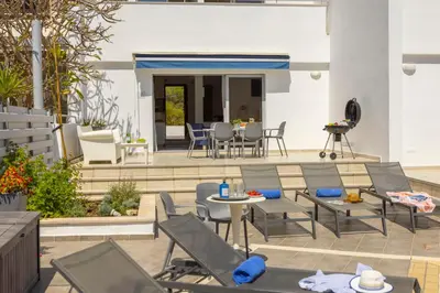 a patio with chairs and tables and a dining area at Pantaros Luxury Villas with pool in Paralimni