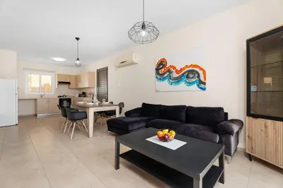 a living room with a couch and a table at Sunny 2Br Family Apartment - Mythical Sands Resort in Protaras