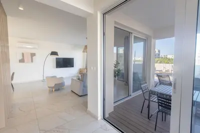 a living room with a sliding glass door to a balcony at Mythical Blue Villas in Protaras