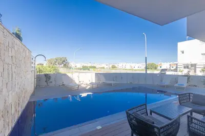 a swimming pool with two chairs and a table at Mythical Blue Villas in Protaras
