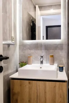 a bathroom with a white sink and a mirror at Panorama Comfort Nest in Paralimni