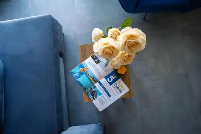 a vase of flowers on a table with a ticket at Stylish Loft - 50m from Beach in Paralimni