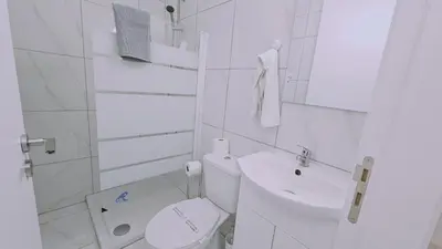 a white bathroom with a toilet and a sink at STAY Terra Cota Studio in Limassol
