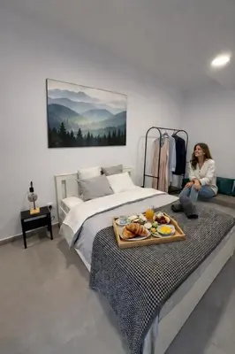 a woman sitting on a bed with a tray of food on it at Limassol center Soul in Limassol