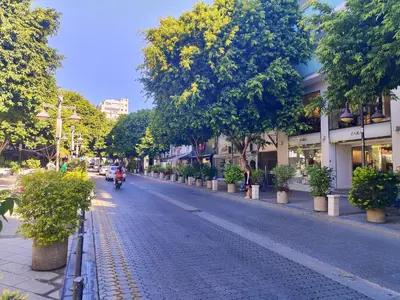 a street with a person riding a motorcycle down the street at Limassol center Soul in Limassol