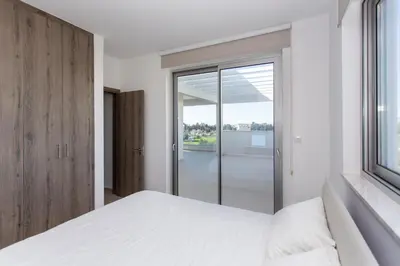 a bedroom with a white bed and a window at BlueStar Limassol Suites in Limassol