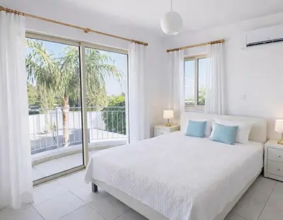 a white bedroom with a bed and a large window at Villa Dolce Vita II in Protaras