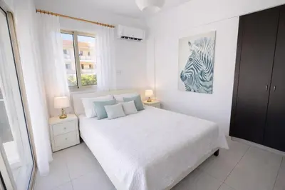 a white bedroom with a bed and a zebra picture at Villa Dolce Vita II in Protaras