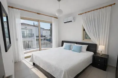 a bedroom with a bed and a large window at Villa Dolce Vita II in Protaras