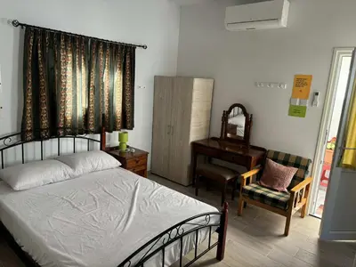 a bedroom with a bed and a chair and a piano at Easy access in Larnaka