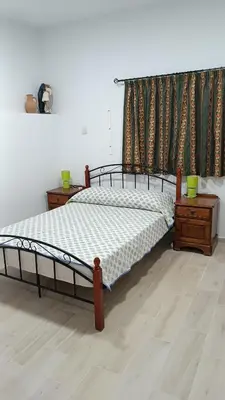 a bedroom with a bed and two night stands and a window at Easy access in Larnaka
