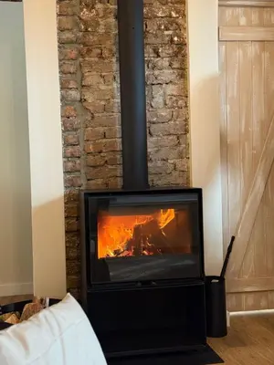 a fireplace in a living room with a fire at Aprosmeno Jacuzzi House 7 in Agros
