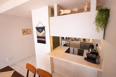 a kitchen with a counter and chairs in a room at Mythical Sands 2 - G in Aglantzia
