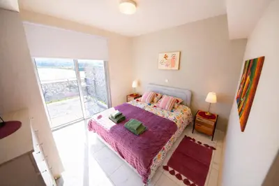 a bedroom with a bed with a purple blanket at Mythical Sands 2 - G in Aglantzia