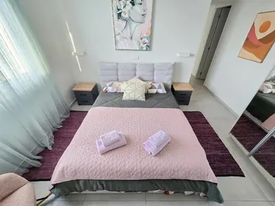 a bedroom with a large pink bed with two pillows at Mythical Sands 2 - B in Paralimni
