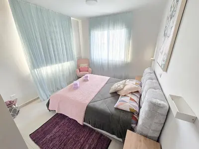 a small bedroom with a bed and a chair at Mythical Sands 2 - B in Paralimni
