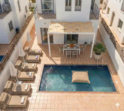 an overhead view of a pool with chairs and a table at Fig Tree Beach Villa Two in Paralimni