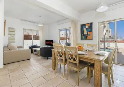 a dining room and living room with a table and chairs at Fig Tree Beach Villa Two in Paralimni