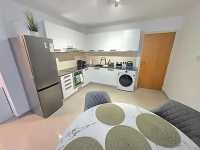 a kitchen with a table and a kitchen with a refrigerator at Thea Court 1 - A in Paralimni