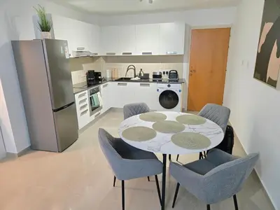 a kitchen with a table and chairs and a refrigerator at Thea Court 1 - A in Paralimni